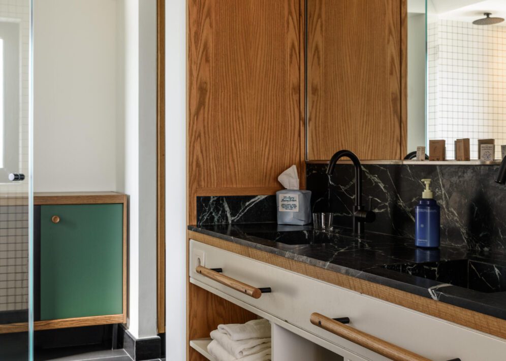 Chic bathroom showcasing a black marble countertop and natural wooden cabinets, creating a cozy atmosphere.
