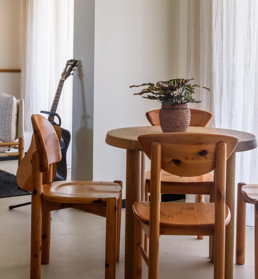 A simple wooden table with chairs set up in a warm, inviting room.